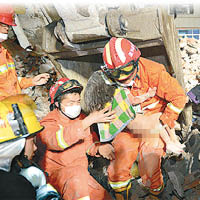 救援人員從瓦礫中救出一名女童。