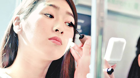東急電鐵新廣告中，有女性在車廂內化妝的畫面。（東急電鐵圖片）