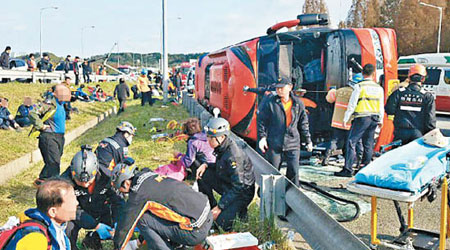 旅遊巴失事翻側，救援人員拯救被困乘客。（南韓警方圖片）