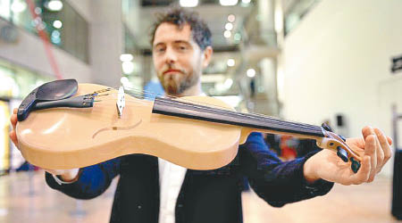 亞歷山德里尼展示以蜘蛛絲及松香製成的小提琴。（倫敦帝國學院圖片）