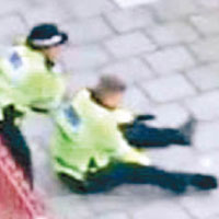 男警員遇襲後坐在地上。（互聯網圖片）