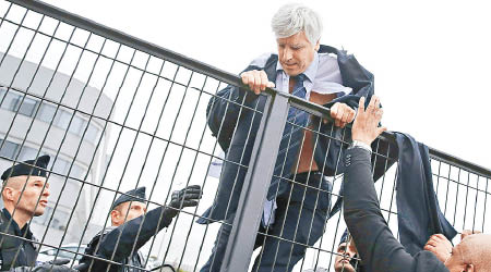 普利索尼耶當日爬越欄杆逃命時，遭示威者扯爛衣物。（資料圖片）