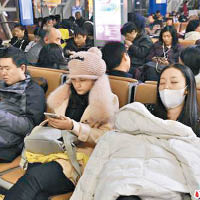 大批旅客在機場休息等候。（互聯網圖片）