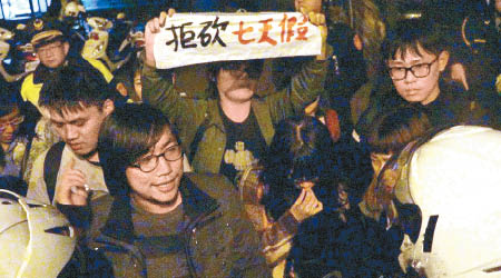 示威青年勞團高舉抗議標語。（互聯網圖片）