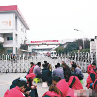 工人坐在廠外罷工，廠方在門口拉上鐵閘。