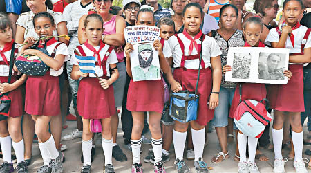 古巴一眾小學生手持卡斯特羅畫像，送別該位革命領袖。