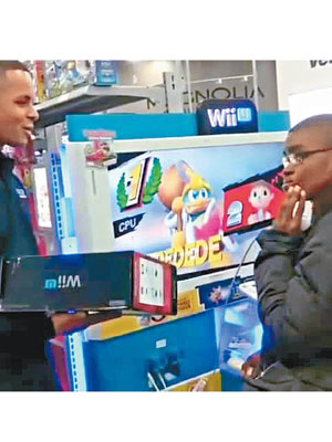 店員（左）送贈遊戲機予男童（右）。（互聯網圖片）