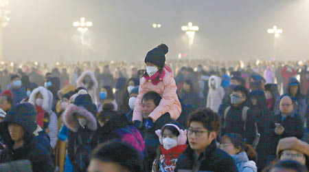 大批戴口罩民眾在霧中的天安門廣場等待觀看升旗儀式。（中新社圖片）