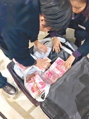 女土豪拖滿載現金的行李篋到百貨公司掃貨。