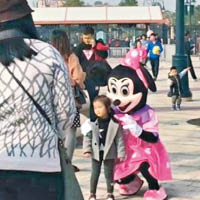 山寨米妮在上海迪士尼小鎮與遊人合照及索取小費。（互聯網圖片）