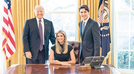伊萬卡（中）坐在總統座椅上，與杜魯多（右）及特朗普（左）合照。（互聯網圖片）