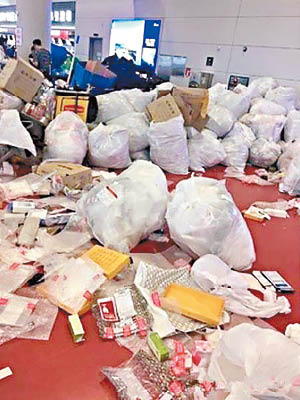 華客在濟州機場拆免稅品包裝，遺下遍地垃圾。（互聯網圖片）