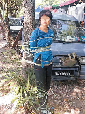 中國籍嫌疑女騙徒遭民眾綁在樹上。