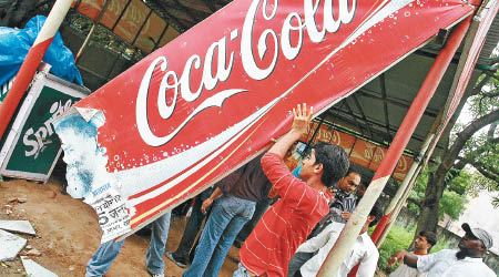 可口可樂近日遭杯葛，圖為印度民眾早年曾推倒該公司的廣告牌。
