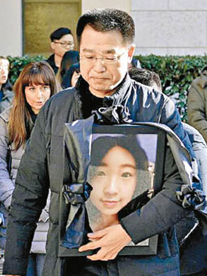 張瑤父親於葬禮上捧着愛女的遺照。（資料圖片）
