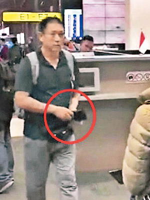 一名中國遊客在印尼機場過關時，從銀包（紅圈）拿錢付小費。（互聯網圖片）