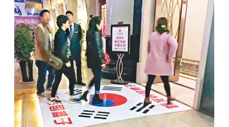陝西有酒店卡拉OK擺放南韓國旗當地氈，予客人踩踏。