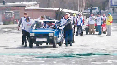 參賽者在冰上以人手推動汽車。