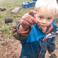 兒童不怕骯髒，在泥中捉蟲。