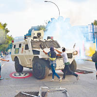 數名示威者攻擊警方裝甲車。