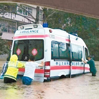 救護車在水中「拋錨」，救護員涉水推車。（互聯網圖片）
