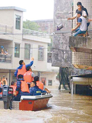 救緩人員坐小舟拯救被困村民。（互聯網圖片）