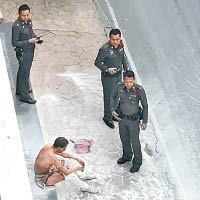 男子（左下）在使館外自焚。