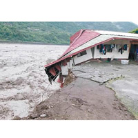 河邊的民宅地基被沖毀，在河邊搖搖欲墜。（中時電子報圖片）