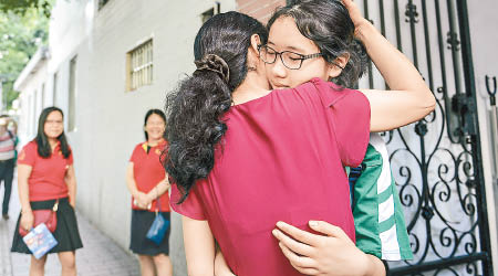 廣州一名母親在考場外與女兒擁抱，以作打氣。（中新社圖片）