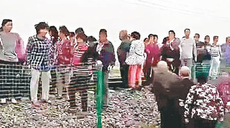大批村民站在路軌上，準備截停火車。