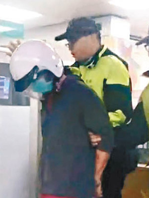 李男（戴頭盔者）被警方押走。（互聯網圖片）