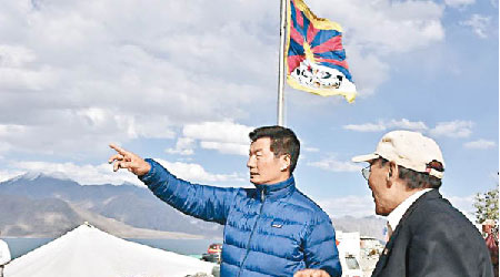 洛桑桑蓋（左）在班公湖印度一側插上「雪山獅子旗」後，手指西藏方向。