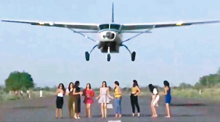 小型飛機在一眾女模身後咫尺爬升起飛。（互聯網圖片）
