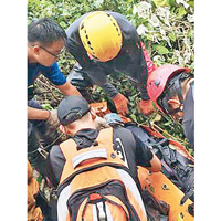 救援人員準備抬走跌落山谷的登山隊員。