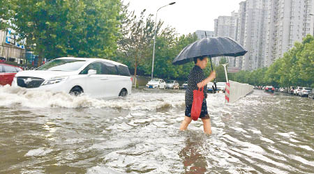 北京多個地區水浸，圖為朝陽區的行人要涉水而行。（互聯網圖片）