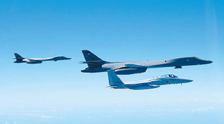 美軍兩架B1B戰略轟炸機（左一及左二），聯同日本F15戰鬥機（下）抵近釣魚島上空。（互聯網圖片）