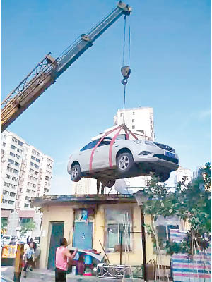 堵塞出入口的私家車被管理處用吊車吊上保安室頂。（互聯網圖片）