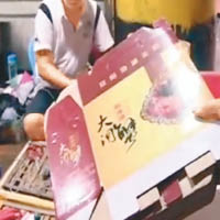 檔主展示一疊「陽澄湖大閘蟹」包裝盒。