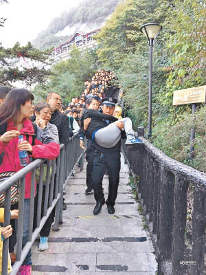 警員抱着孕婦下山，將她送院。（互聯網圖片）