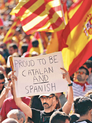 有民眾高舉口號牌，為西班牙人身份感自豪。（美聯社圖片）