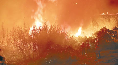 消防員積極灌救山火。（美聯社圖片）