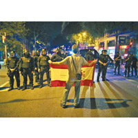 反獨人士在防暴警察面前展示西班牙國旗。（美聯社圖片）