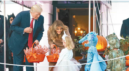 特朗普（左） 偕妻於萬聖節向小孩派糖。（美聯社圖片）