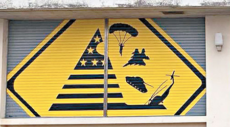 《小心美軍機墜落》壁畫模仿落石警告牌。（互聯網圖片）