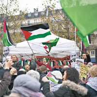 巴黎示威者在共和廣場高舉巴勒斯坦旗幟抗議。（美聯社圖片）