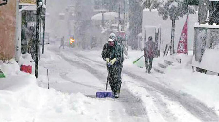 民眾清除積雪。（電視畫面）