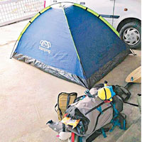 兩名外國遊客在黃華黎家的車位上紮營。（互聯網圖片）