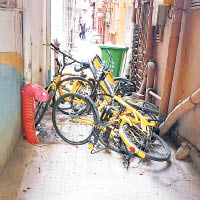 共享單車被堆放在暗巷。