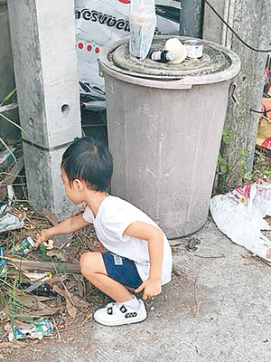 小男童沿街拾膠樽。