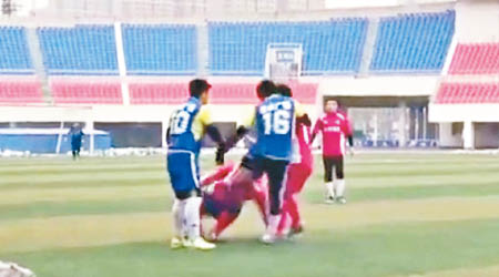 身穿藍衣的兩名球員先後出手襲擊紅衣球員。